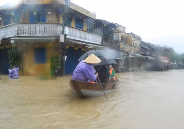 Du khách thích thú với mùa nước lũ ở phố cổ Hội An, họ thuê thuyền bơi đi dạo.