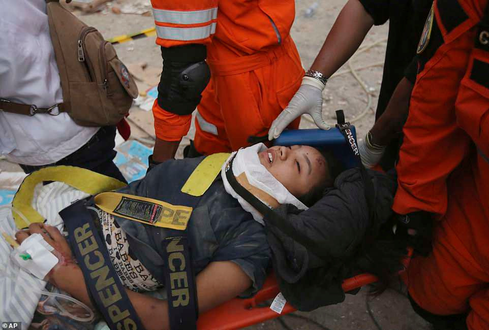 Lực lượng cứu hộ đưa một nạn nhân sống sót ra khỏi cửa hàng bị hư hại do động đất tại Palu sáng 30/9. Ảnh: AP.