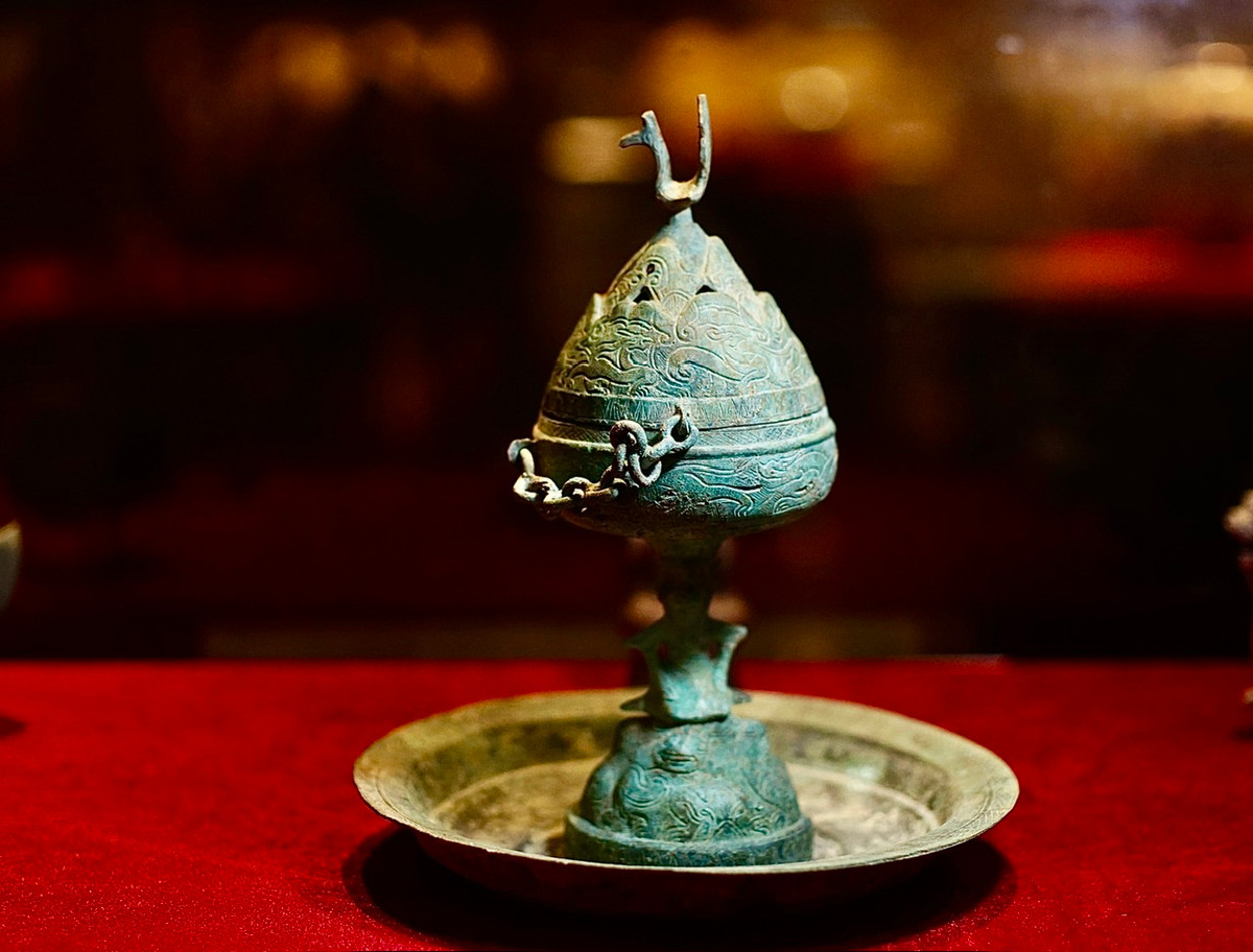 Đèn đồng trang trí người đội đèn, đỉnh nắp có chim phượng. Niên đại thế kỷ 1-3