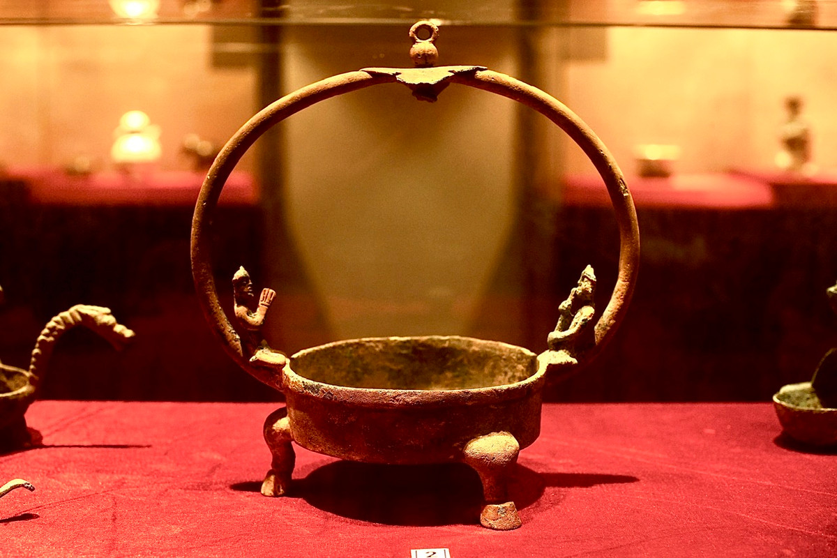 Đèn dầu đồng quai trang trí cặp người, chân hình móng ngựa, niên đại thế kỷ 1-3. 