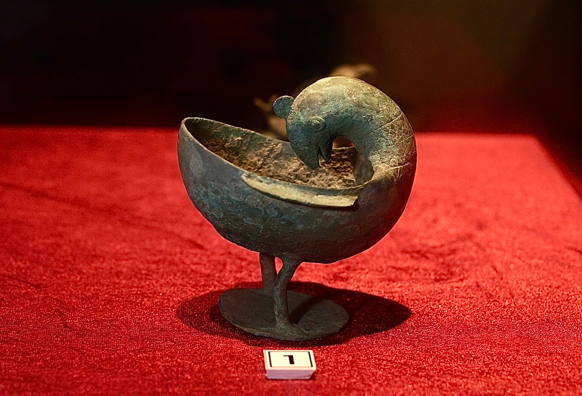 Đèn dầu đồng có hình chim vẹt quay đầu vào lòng nhĩ bôi, niên đại thế kỷ 1-3.