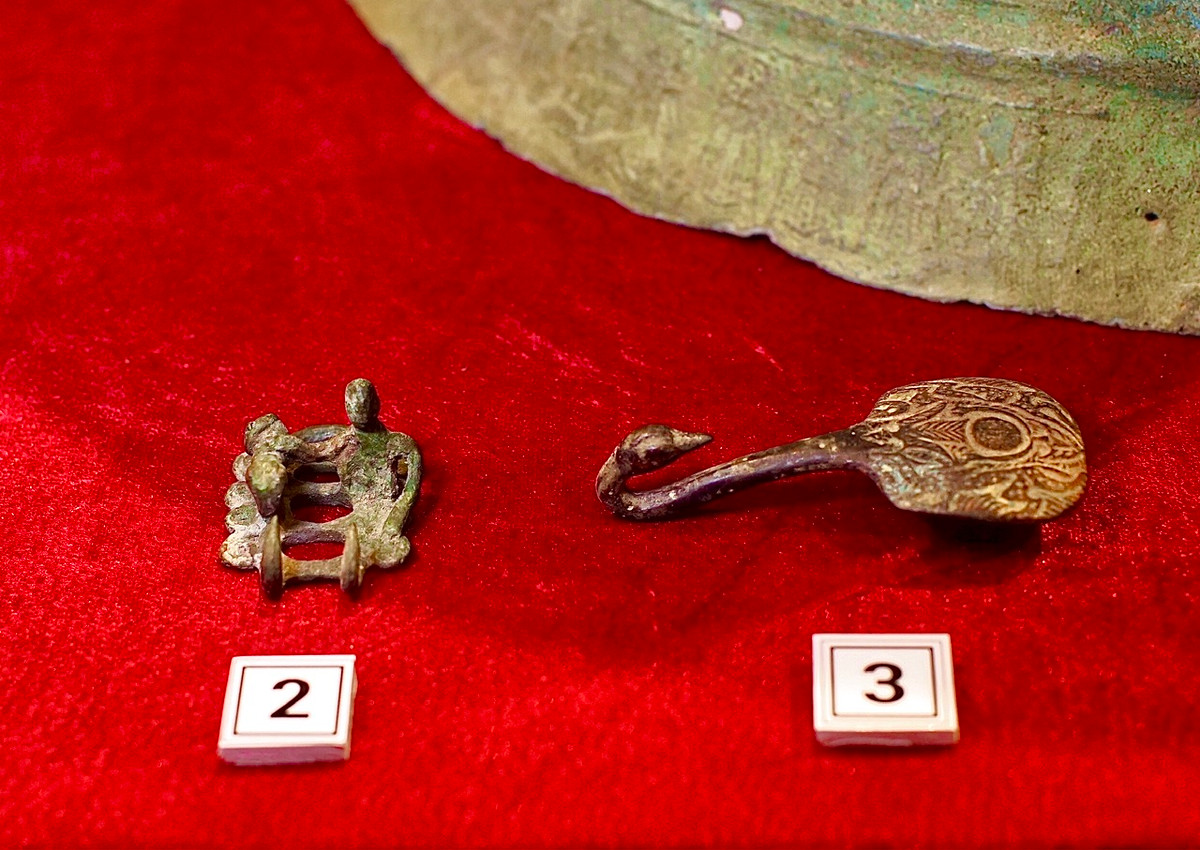 Tượng người ôm chó bằng đồng của khoá thắt lưng và khuy cài thiên nga bằng đồng.