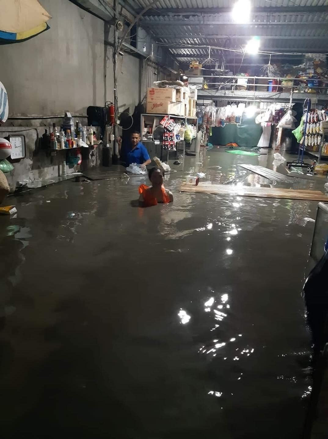 Không chỉ ngập sâu trên các tuyến phố, ở một số nhà dân thấp hơn mặt đường cũng chịu tình cảnh tương tự khi nước tràn vào nhà và ngập quá nửa người. Hình ảnh ghi nhận tại một quán tạp hóa ở phường Hà Khánh cho thấy nhà bị ngập sâu, gây hư hỏng nhiều hàng hóa và vật dụng.