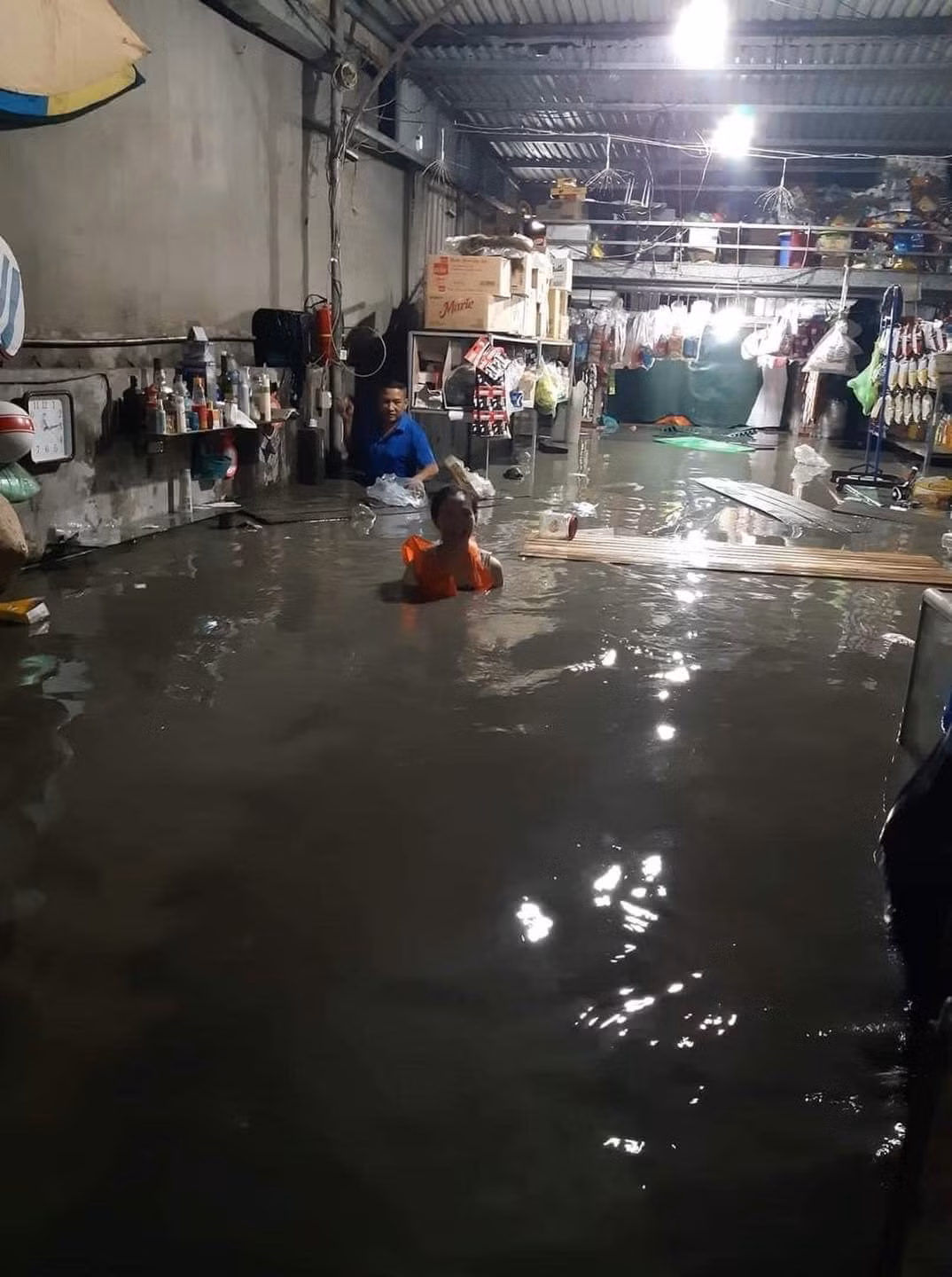 Không chỉ ngập sâu trên các tuyến phố, ở một số nhà dân thấp hơn mặt đường cũng chịu tình cảnh tương tự khi nước tràn vào nhà và ngập quá nửa người. Hình ảnh ghi nhận tại một quán tạp hóa ở phường Hà Khánh cho thấy nhà bị ngập sâu, gây hư hỏng nhiều hàng hóa và vật dụng.