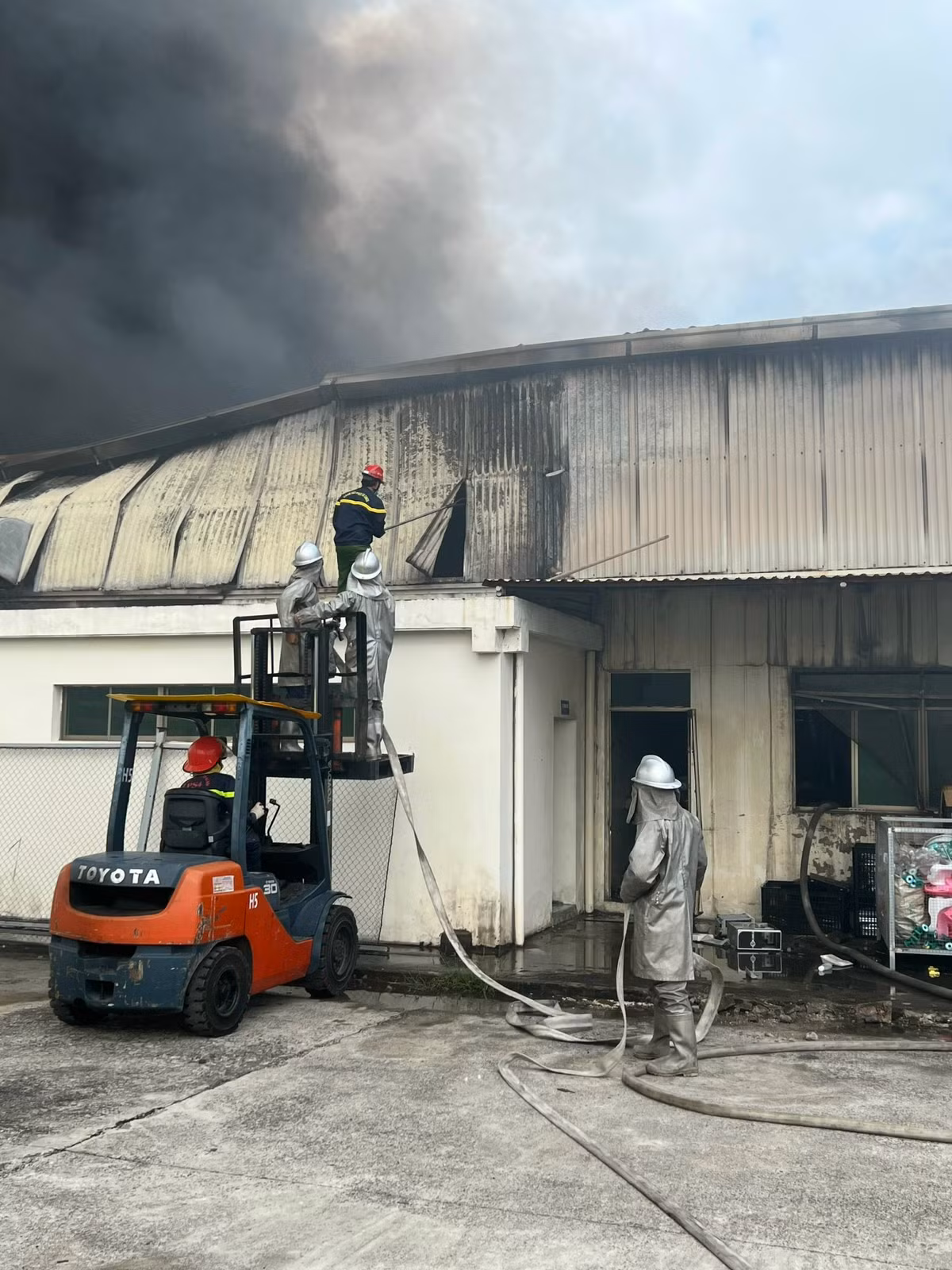 Lực lượng Cảnh sát PCCC&amp;CNCH triển khai phá dỡ một phần tường công trình để chữa cháy.