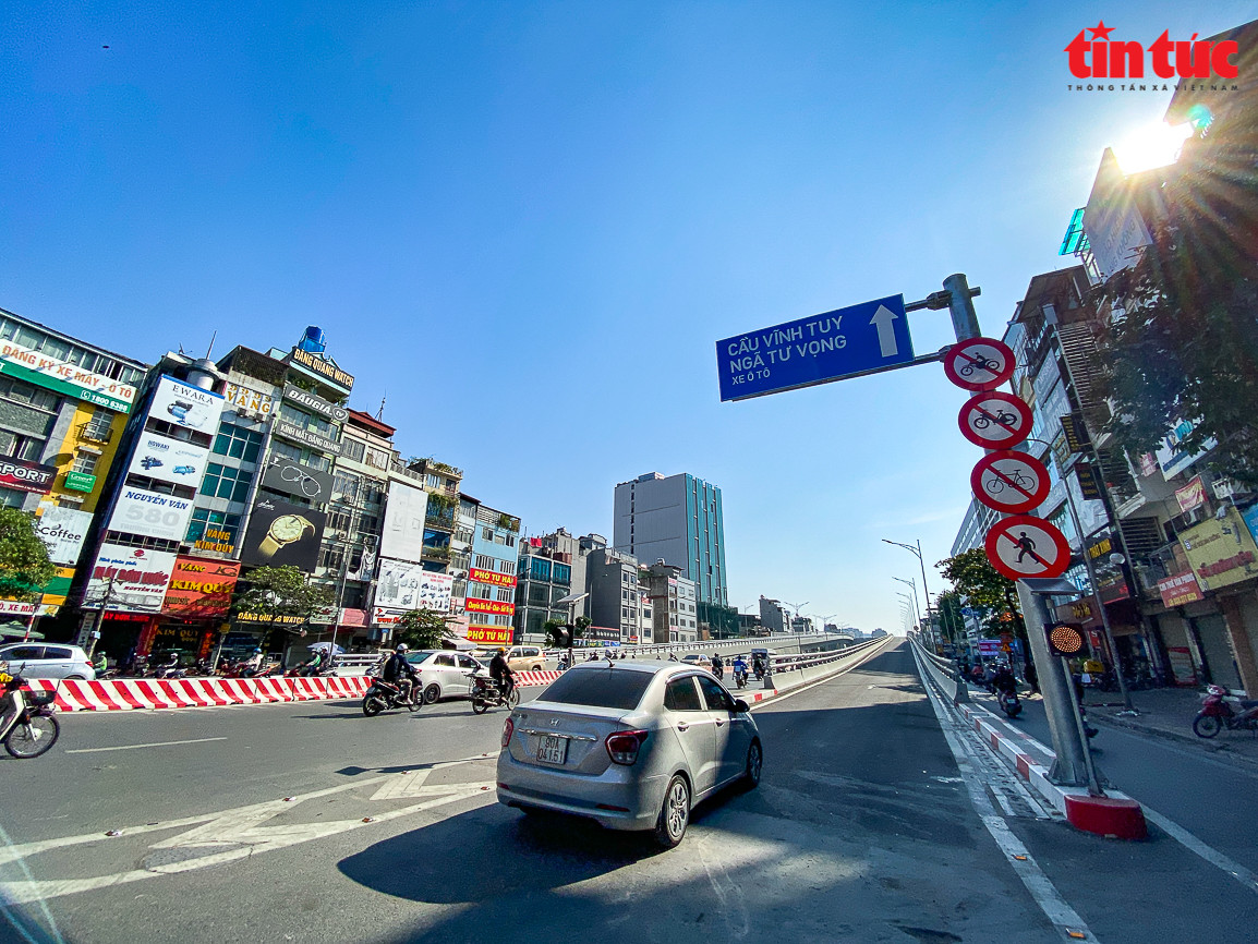 Việc thí điểm điều chỉnh tổ chức giao thông tại nút giao Ngã Tư Sở được thực hiện như sau: Cấm các phương tiện trên đường Tây Sơn (dưới thấp) rẽ trái và đi thẳng qua nút giao Ngã Tư Sở, các phương tiện lưu thông theo hướng từ Tây Sơn rẽ phải liên tục ra đường Láng và quay đầu tại điểm mở dải phân cách trên đường Láng để đi thẳng ra đường Trường Chinh hoặc rẽ phải liên tục ra đường Nguyễn Trãi. (Ảnh Báo Tin Tức).