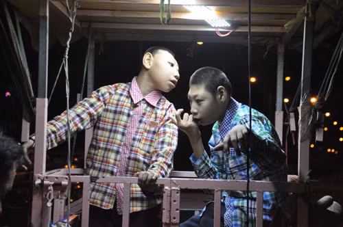 Anh mua xe máy cũ và thiết chiếc lồng sắt cho hai con trai ngồi bên trong. Mỗi tuần, anh chở theo hai con trai đi hát rong bán kẹo khoảng 3, 4 lần.