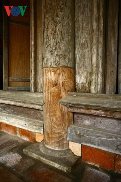 Một cây cột được thay thế phần chân. Chân cột được đỡ bởi đế bằng đá xanh. Các phần thay mới đều được đánh dấu ghi rõ thời gian trùng tu.