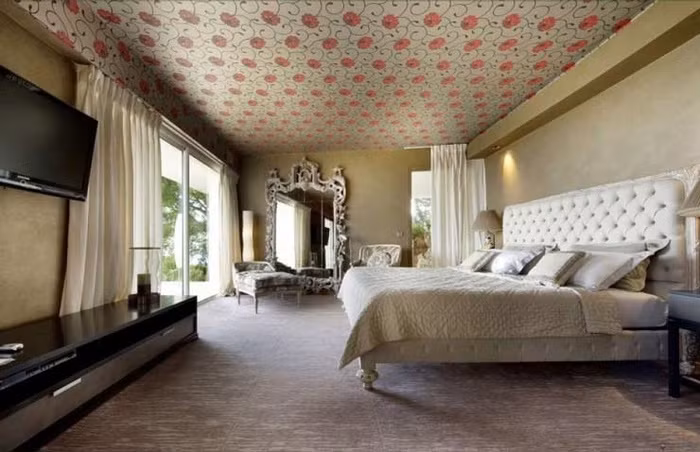 Phòng ngủ được trang trí với bảng màu trung tính thì giấy dán tường sử dụng để dán trần sẽ giúp cho không gian đẹp mềm mại và duyên dáng hơn.