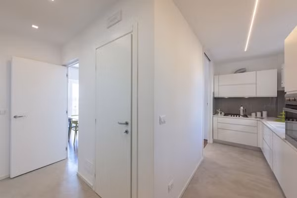 Phòng bếp nhỏ ấn tượng với gam màu trắng của tủ bếp và màu ghi xám của tường. Ảnh: HomeDesign.