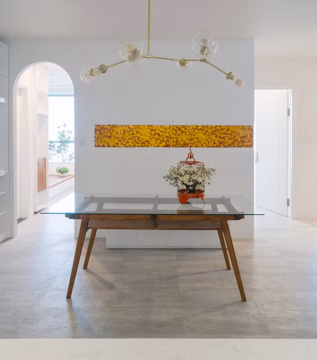 Để thêm được quầy bar và làm phòng ăn rộng hơn, kiến trúc sư đã lùi tường vệ sinh vào 40 cm. Vị trí bếp được thiết kế như một mái nhà với tủ tường trắng sáng kết hợp với mảng gỗ trang trí lấy ý tưởng từ các cánh cửa nhà dân gian.