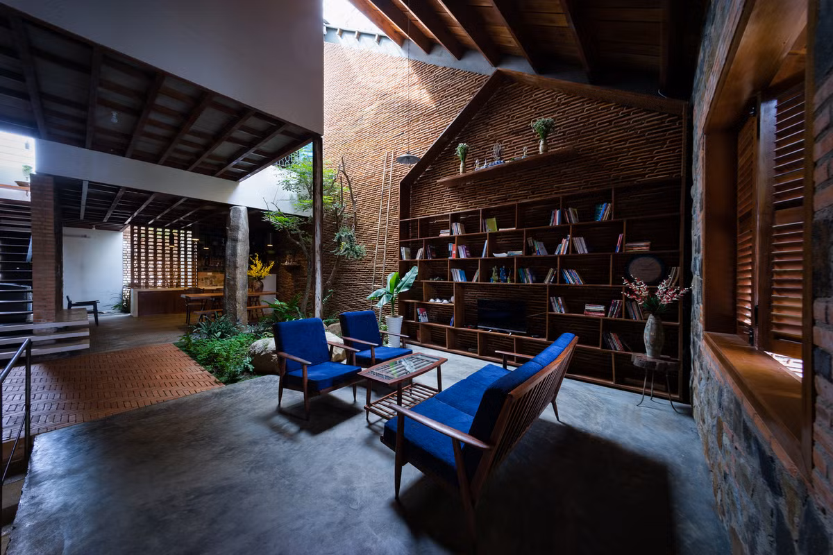 Phòng khách giản dị với ghế sofa nhỏ và tường gạch thô mộc mạc.