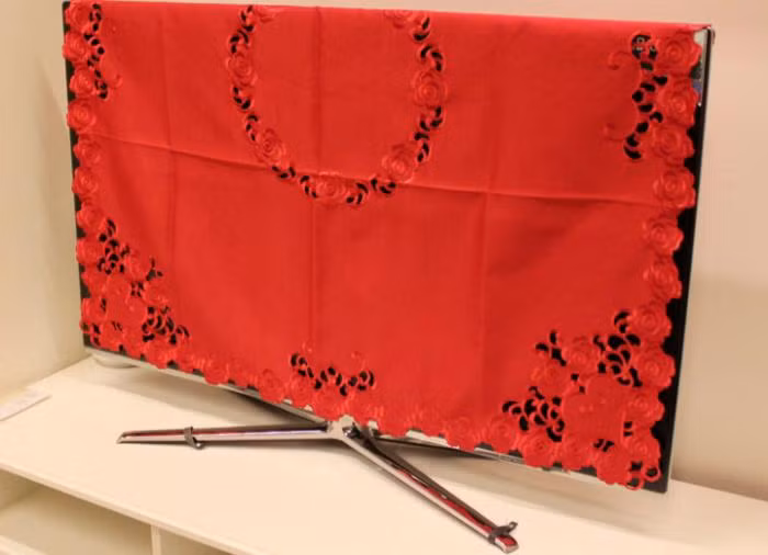 Dùng khăn phủ ti vi giúp hạn chế bụi nhưng che khăn ngay khi tắt làm ti vi không thoát được nhiệt, ảnh hưởng trực tiếp đến tuổi thọ ti vi. Ảnh: Điện máy xanh.