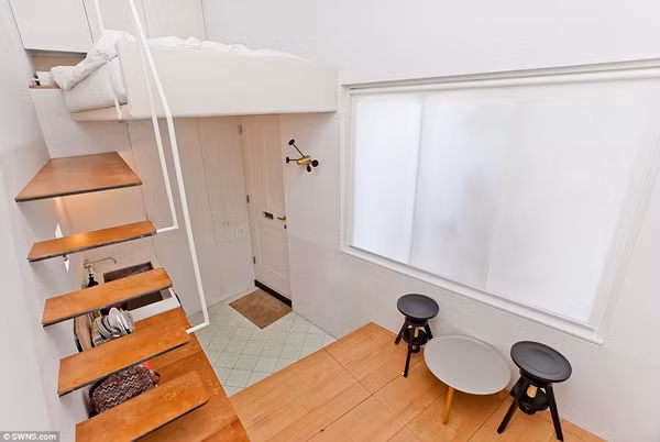 Chỉ nhỏ bằng 1/5 so với diện tích mặt bằng trung bình nhưng ngôi nhà vẫn sở hữu đầy đủ không gian sinh hoạt: một phòng bếp mở, phòng khách, phòng tắm và phòng ngủ. Cửa ra vào nằm dưới giường ngủ. Ảnh: Swings.