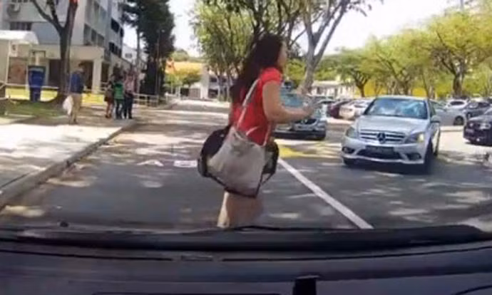 Mải nhắn tin điện thoại mà không biết phía trước là ô tô đang lao tới. Ảnh: Stomp.