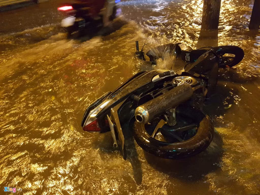 Xe máy bị sóng đánh ngã.