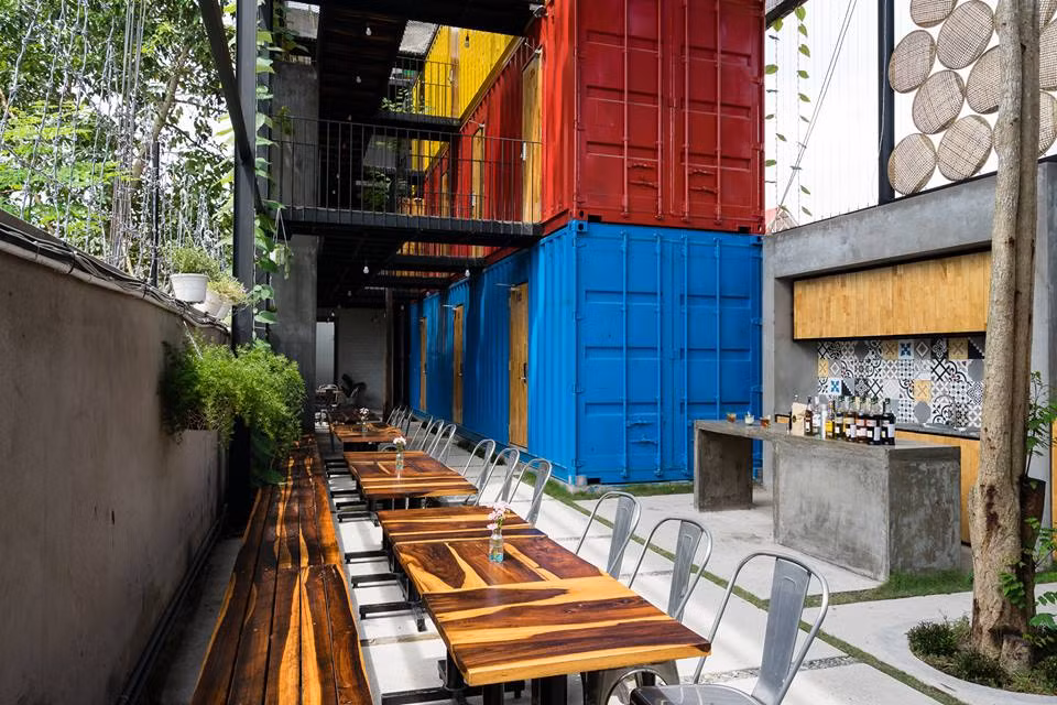 Với thiết kế mở hoàn toàn, khách sạn có cả khoảng sân vườn cùng dãy bàn gỗ siêu đẹp.