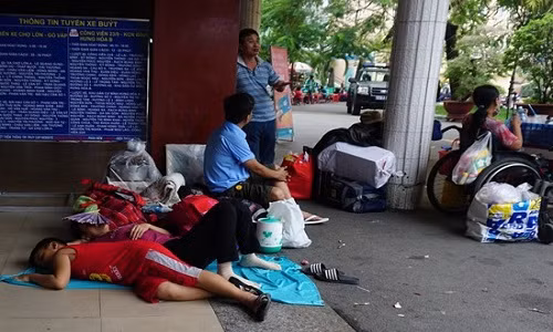 Từ chiều tối 20/1 (nhằm 23 tháng Chạp), nhiều gia đình có con nhỏ đổ về Ga Sài Gòn chờ tàu về quê ăn Tết. Họ có mặt từ rất sớm trước giờ tàu chạy, buộc các cô, cậu bé phải chờ đợi. Trong ảnh, một cậu bé nằm ngủ cùng mẹ ngoài sân ga. Gia đình em có mặt từ 12h trưa để đợi chuyến tàu khởi hành lúc 7h tối.