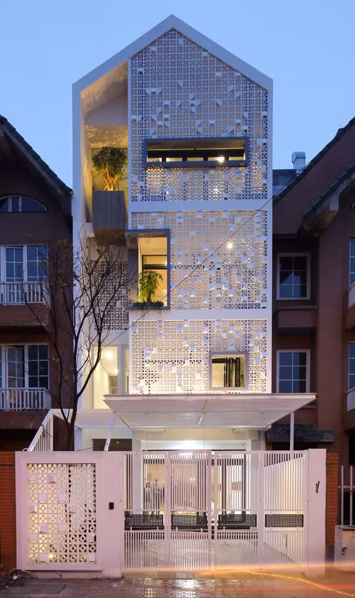 Ngôi nhà được bao bọc bởi lớp gạch thông lỗ sơn trắng, vừa tiếp xúc với cây xanh vừa đảm bảo sự an toàn. Ảnh: Thietkenhagiare.