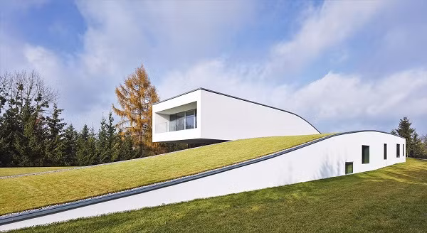 Mái nhà được phủ xanh bằng cỏ. Mái nhà xanh khiến ngôi nhà như biến mất bởi sự pha trộn hoàn hảo của màu cỏ và cây cối xung quanh.