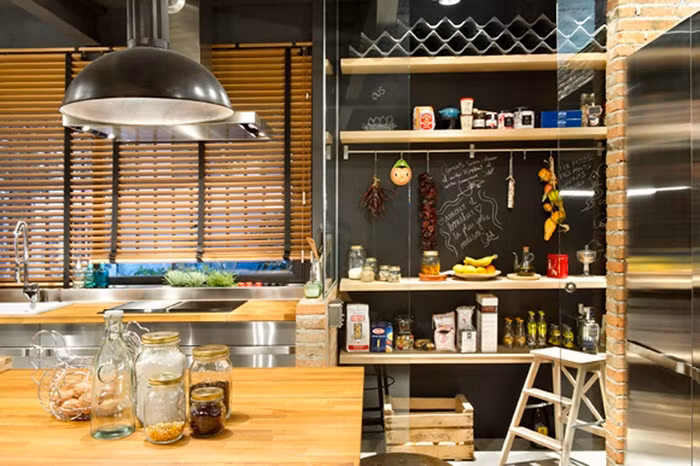 Thay vì sử dụng quá nhiều tủ khiến không gian trở nên nặng nề, gia chủ đã khéo léo “chèn” thêm hệ thống kệ gỗ, giúp không gian nấu nướng ngăn nắp và gọn gàng hơn.