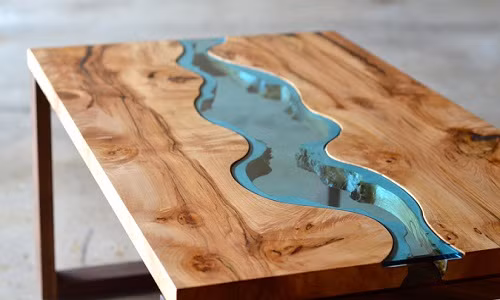 Sự kết hợp khéo léo giữa gỗ tự nhiên và kính đã tạo ra dòng sông kính chạy giữa bàn. Nguồn ảnh: TD.