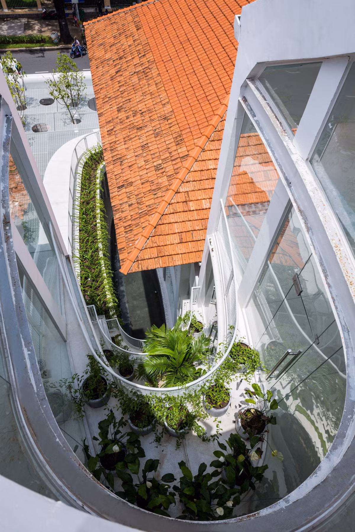 Mong muốn mở rộng không gian sống và giữ nguyên căn nhà cũ, kiến trúc sư chọn phương án xây thêm một hệ khung thép 4 tầng, tường kính xung quanh ngôi nhà.