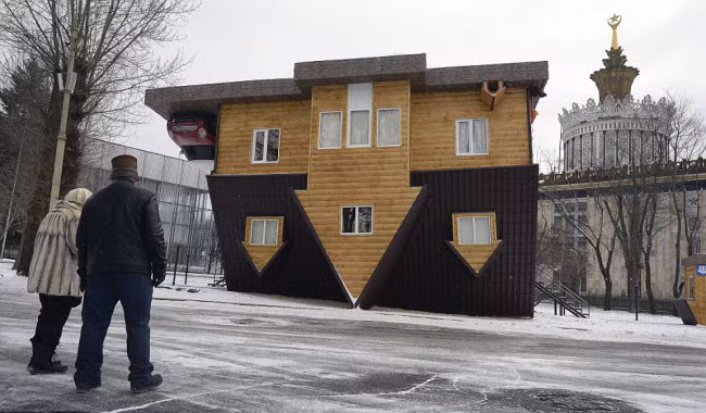 Mọi người chiêm ngưỡng ngôi nhà lộn ngược được trưng bày tại Trung tâm triển lãm toàn Nga ở thành phố Moscow.