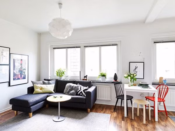 Cạnh đó là phòng khách với sofa góc và bàn trà nhỏ.