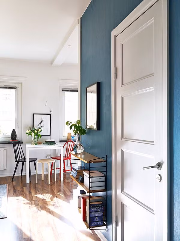 Ngay lối cửa chính đi vào là một giá sách nhỏ và chiếc bàn làm việc xinh xắn.