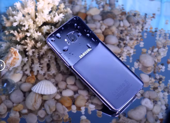 Trong bối cảnh bãi biển ngập nắng, màu sắc chủ đạo ở mặt lưng thiên về gam tím huyền bí. Dưới mặt nước, flagship này lại mang sắc xanh tím. Kết hợp khéo léo 2 chất liệu kính và kim loại, Galaxy S8+ phiên bản mới khai thác tối đa khả năng phản chiếu ánh sáng tự nhiên. Khả năng kháng nước, kháng bụi cũng là ưu điểm của dòng smartphone cao cấp.