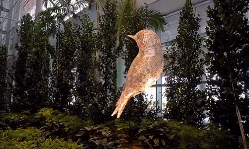 Tác phẩm nghệ thuật Chú chim bằng thép không gỉ trưng bày tại ga đến như một biểu tượng của mối liên hệ giữa trời và đất, giữa giấc mơ và hiện thực. Ảnh: cắt video của Yahoo Lifestyle