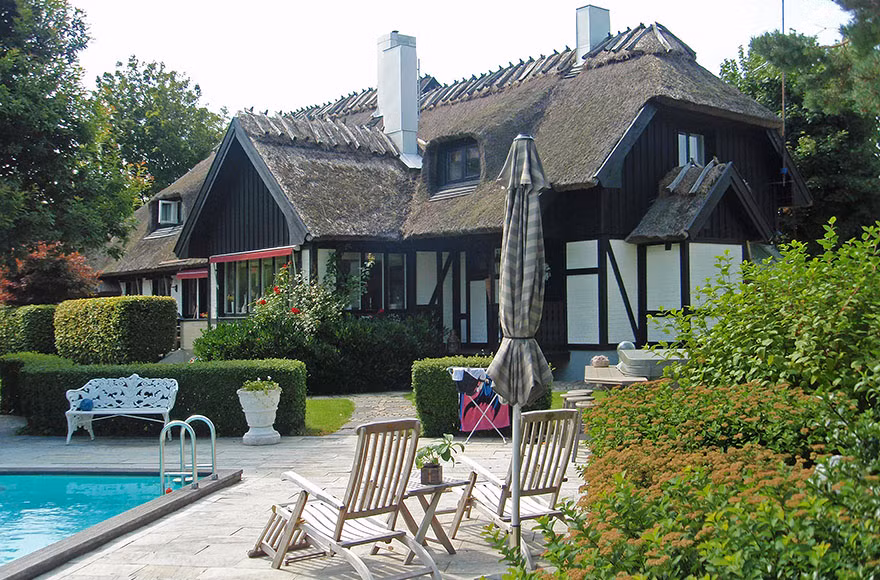 Được xây dựng trên khuôn viên rộng, căn biệt thự vườn xanh mướt giữa những khóm hoa nhỏ hay những luống cây cảnh được tỉa tỉ mỉ. Ảnh: Archdaily.