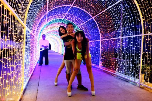 Trong bữa tiệc, hai cô mẫu bikini diện nội y phát quang luôn đi theo nhảy múa và tạo dáng uốn éo chụp ảnh với cậu thiếu gia Trung Quốc. Ảnh: Sina