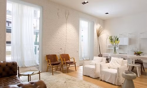 Khu vực tiếp khách được bố trí gọn thoáng với ghế sofa mang phong cách cổ điển. Ghế sofa được đặt sát bức tường để gạch trần, giữ nguyên màu gạch giúp cho chiếc ghế màu nâu trầm bỗng trở nên nổi bật khi trở thành điểm nhấn đặc biệt cho không gian.