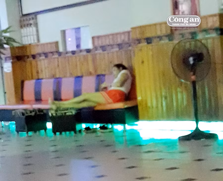 Cô gái ăn mặc hở hang ngồi đợi khách massage.