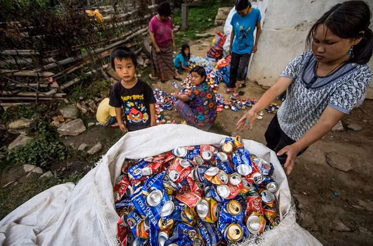 Trẻ em và phụ nữ đang rửa can nhựa để tái chế.