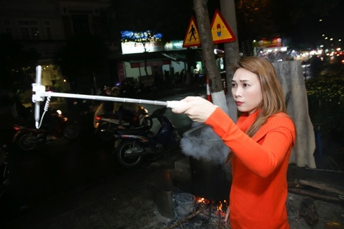 Cô nàng còn mang điện thoại ra ngoài sân để quay cảnh nấu bánh tét, làm mứt dừa và chỉ dẫn các fan bí quyết thực hiện các món ăn cổ truyền cho ngày Tết này.