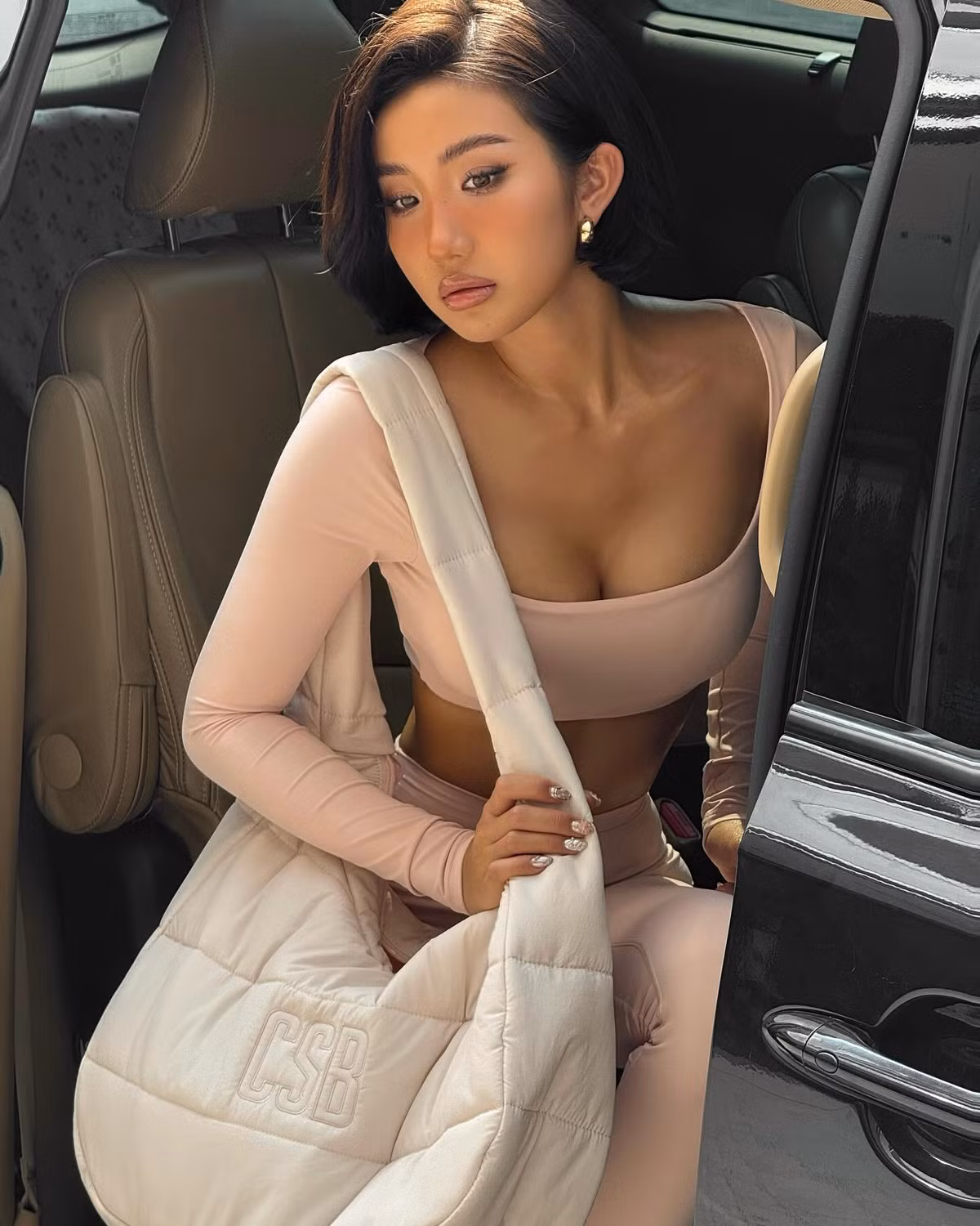 Cô nàng diện bộ outfit thể thao ôm sát tông hồng pastel, kết hợp với túi xách cùng tông và giày thể thao, mang đến vẻ đẹp vừa khỏe khoắn vừa gợi cảm.