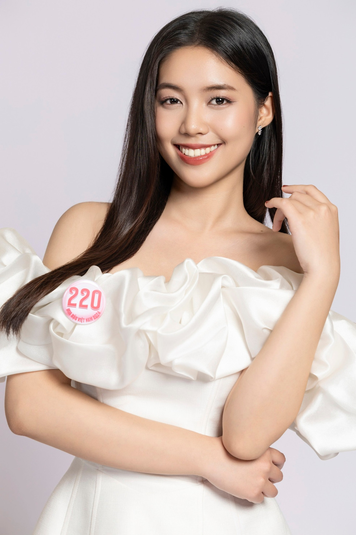 Thiết kế váy trễ vai có phần bèo nhún lớn giúp cô nàng khoe trọn phần xương quai xanh gợi cảm. Kết hợp với kiểu tóc thẳng đơn giản cùng lối trang điểm nhẹ nhàng, cô nàng "bừng sáng" dù đứng cạnh dàn thí sinh xinh đẹp khác.