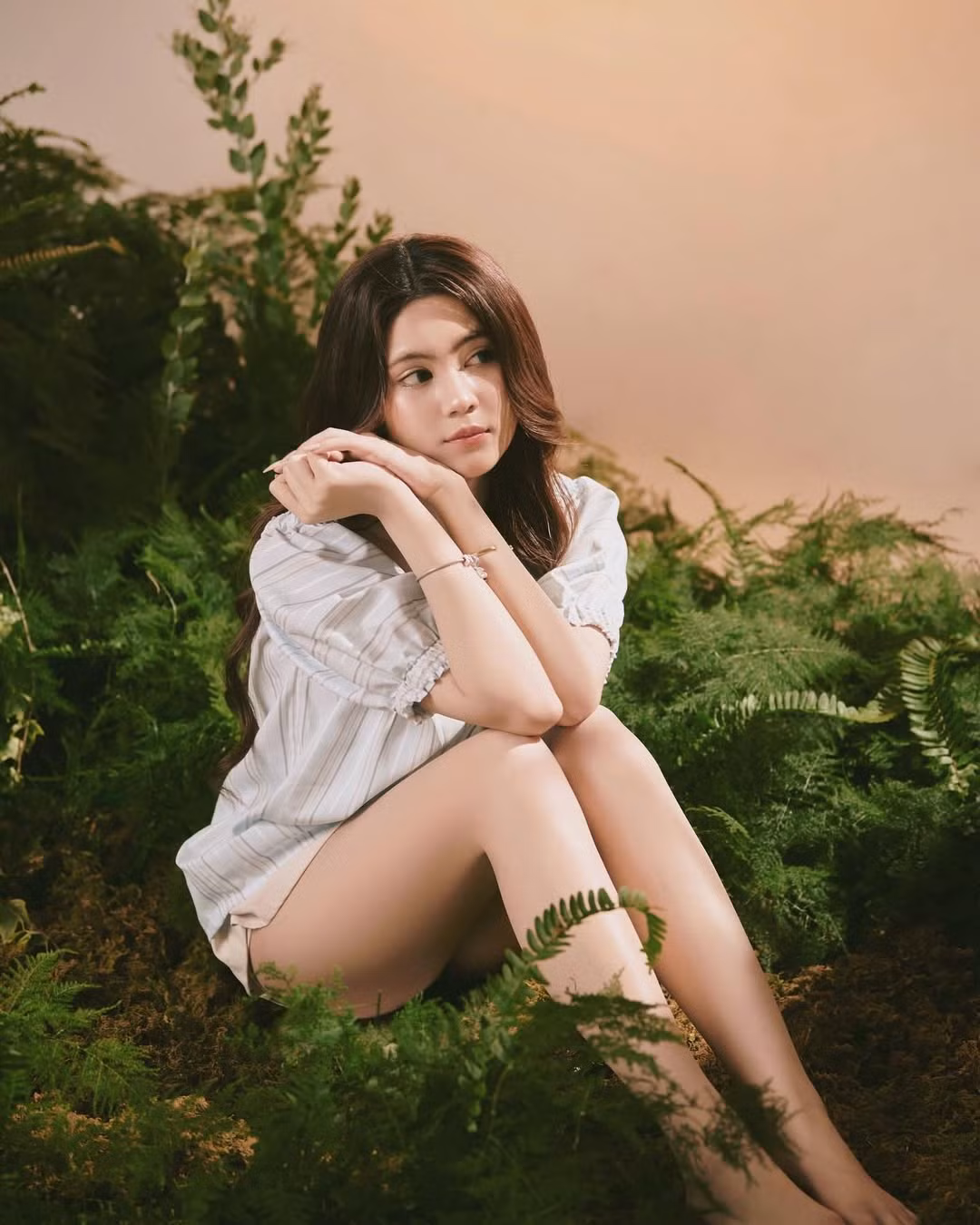 Trong loạt ảnh, Hạt Dẻ diện trang phục theo xu hướng "giấu quần", kết hợp áo blouse trắng nhẹ nhàng với quần short ngắn tiệp màu, giúp tôn lên đôi chân dài thẳng tắp đáng ngưỡng mộ.