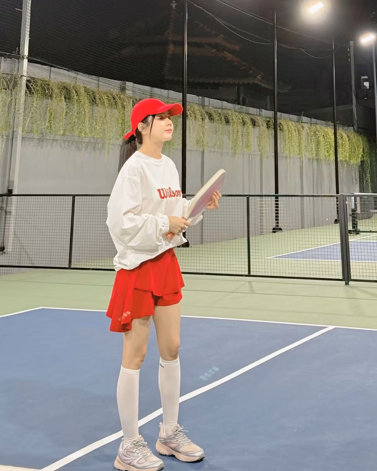 Xuất hiện trên sân đấu, DJ Mie diện outfit thể thao trẻ trung với tone trắng - đỏ làm chủ đạo. Cô nàng kết hợp áo sweater trắng với logo Wilson, chân váy tennis đỏ năng động, tất cao cổ và giày thể thao cá tính.