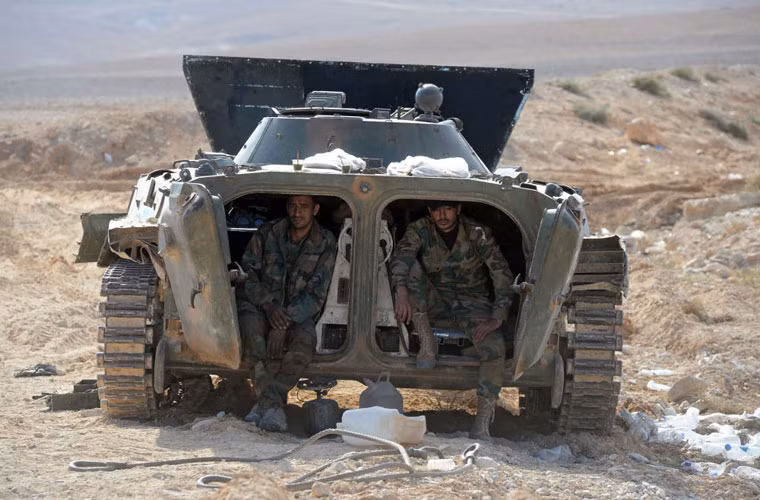 Hai binh sĩ Quân đội Syria với dáng vẻ mệt mỏi ngồi trong xe chiến đấu bộ binh BMP-1 tại điểm kiểm soát cách thành phố Palmyra 20km.