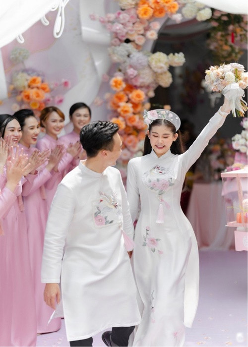 Trong ngày trọng đại, Ngân Anh và Tô Ny diện áo dài trắng thêu đóa bạch trà, chim hồng hạc. Mẫu áo dài gửi gắm về một hạnh phúc tròn đầy, sung túc, viên mãn cho cô dâu chú rể. Ảnh: Người đưa tin
