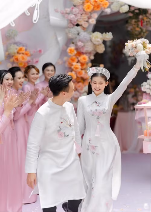 Trong ngày trọng đại, Ngân Anh và Tô Ny diện áo dài trắng thêu đóa bạch trà, chim hồng hạc. Mẫu áo dài gửi gắm về một hạnh phúc tròn đầy, sung túc, viên mãn cho cô dâu chú rể. Ảnh: Người đưa tin
