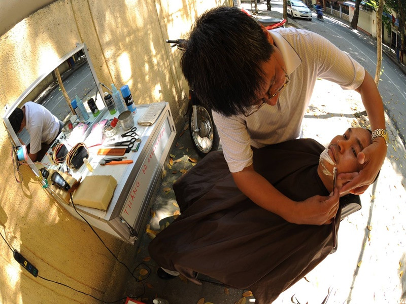 Dù giàu có, Xuân Hinh vẫn cắt tóc vỉa hè. Ảnh: FBNV