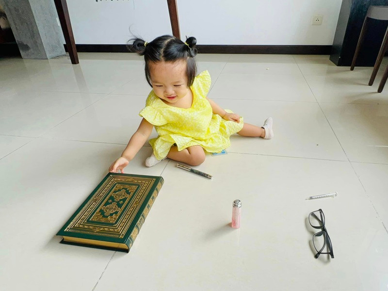 Bé Kỳ Yên lựa chọn món đồ yêu thích là sách trong tiệc sinh nhật.