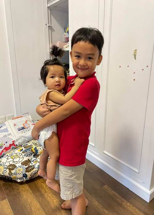 Con trai Lê Bê La vừa đi học về đã bế em gái.