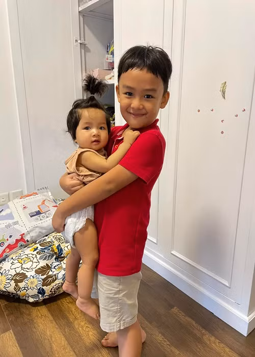 Con trai Lê Bê La vừa đi học về đã bế em gái.