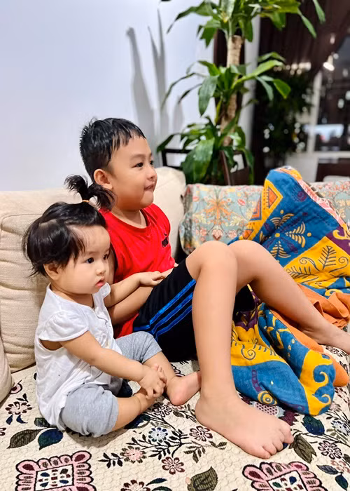 Hai nhóc tì nhà Lê Bê La ngồi xem tivi trong lúc nữ diễn viên nấu cơm.